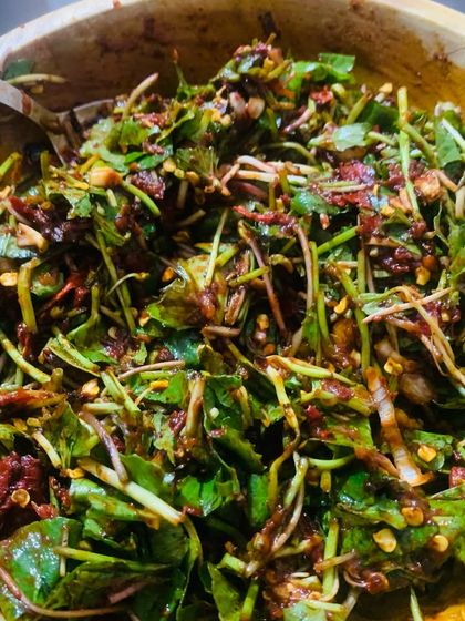 This is a pennywort salad, a very refreshing and healthy side dish. I mix the fresh leaves with roasted red chillies, tomatoes, garlic, and fermented roasted dried fish.