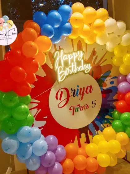 A vibrant rainbow-colored balloon ring for a Holi-themed or color-themed 5th birthday.