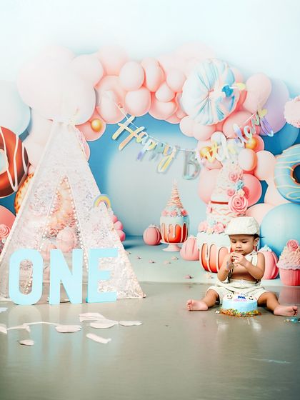 Getting right into the spirit of the celebration! This candid shot shows the birthday boy curiously exploring his cake during his fun and messy cake smash session.