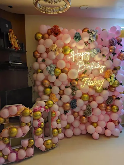 This is another angle of the dense balloon wall created for a 25th birthday at home. The setup includes custom balloon-filled marquee numbers, adding a unique and personalized element to the decor.