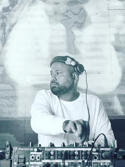 Another black and white portrait from behind the decks, capturing a moment of concentration during a set.