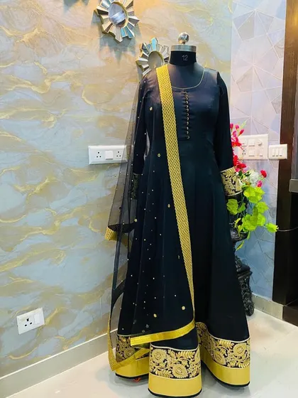 A classic black Anarkali suit with rich gold embroidery on the border and a matching sheer dupatta. This is a very elegant and regal choice for any formal occasion.