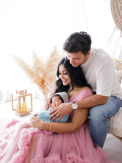 A wider view of a family portrait session, showing how the flowing gown and studio decor come together to create a dreamy, artistic photograph.