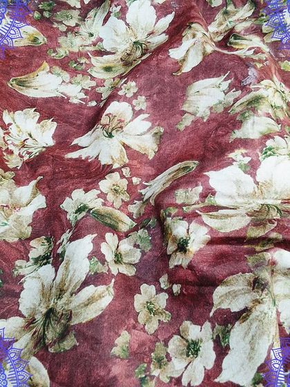 A rich maroon fabric with a delicate digital floral print. The soft texture makes it a great choice for a flowing dress or a stylish top.