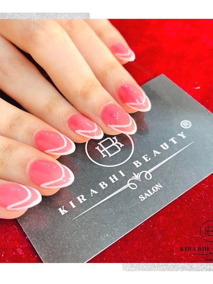 This design features a sheer pink base with a delicate, wavy white line accentuating the tip. It's a simple, elegant, and modern nail art style.