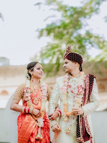 A low-angle shot of the couple looking at each other, with the green trees and sky in the background. This composition adds a sense of grandeur to their portrait.
