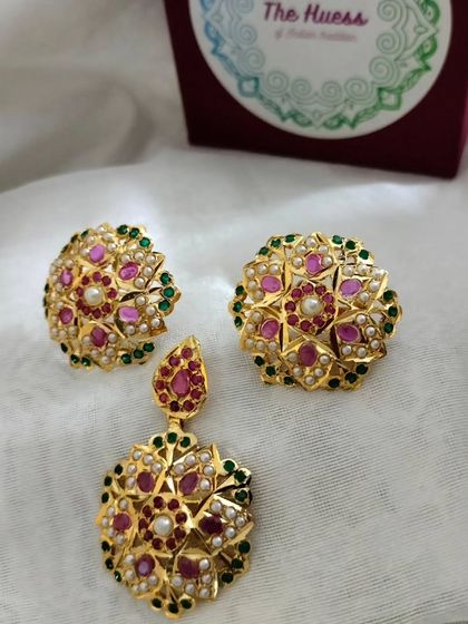 The complete view of the floral pendant set, showing the pendant and matching stud earrings. It's a perfect example of timeless Jadau artistry.