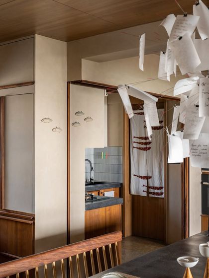 The kitchen and dining area are designed to be the bustling heart of the home. The open layout encourages interaction, with details like the hanging paper art adding a touch of personal whimsy.