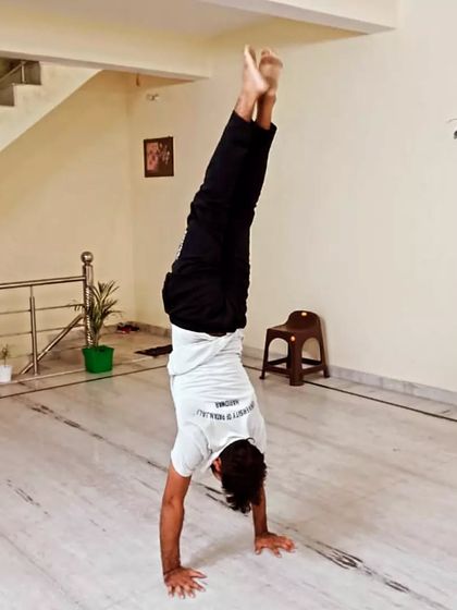 A student holds a steady Adho Mukha Vrksasana (Handstand) in our studio. This powerful inversion builds incredible upper body and core strength, improves balance, and boosts confidence.