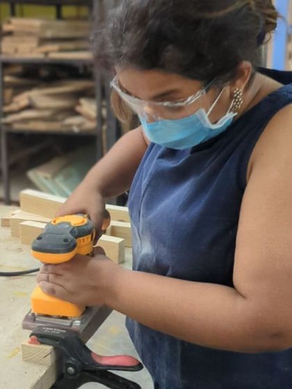 An orbital sander is your best friend for achieving a super smooth finish. Here, a participant preps her wooden pieces before assembly.