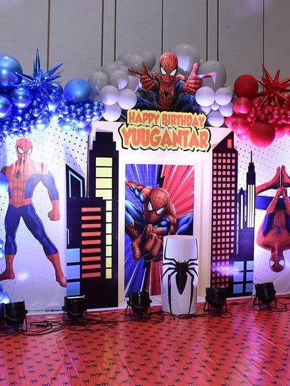 The full view of this spectacular Spider-Man stage setup for Yuvaan's 4th birthday. I used dramatic red and blue balloon arches, city skyline props, and multiple Spider-Man figures to create a dynamic, action-packed scene.