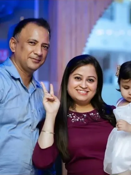 A happy family of three posing for a picture at a party. These classic family portraits are a staple of my event photography service.