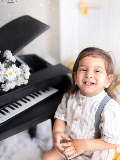 A beautiful, happy smile from a little boy in a dreamy, star-filled setting. The soft lighting and fluffy clouds create a magical atmosphere.