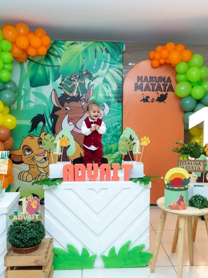 A little boy stands proudly in his 'Lion King' themed first birthday setup. We love capturing children's portraits that highlight their personality amidst the creative decor of their special day.