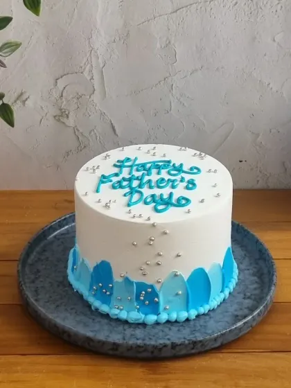 This "Happy Father's Day" cake features silver sprinkles and a two-tone blue design, offering a modern and celebratory look.