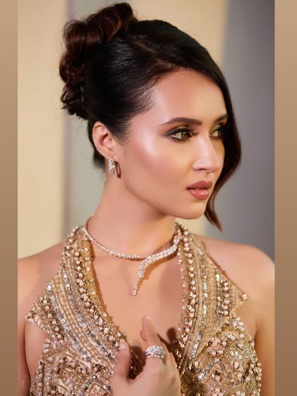 A close-up profile view of the cocktail updo. The soft wave framing her face adds a touch of old-world glamour to this modern hairstyle.