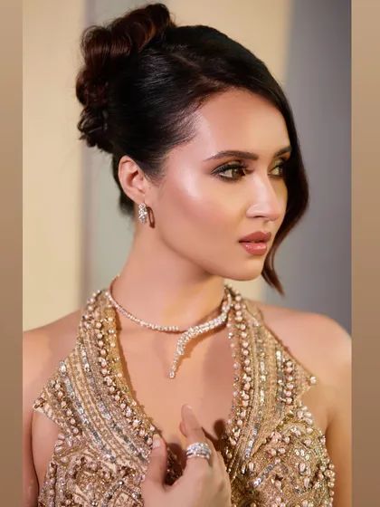 A close-up profile view of the cocktail updo. The soft wave framing her face adds a touch of old-world glamour to this modern hairstyle.