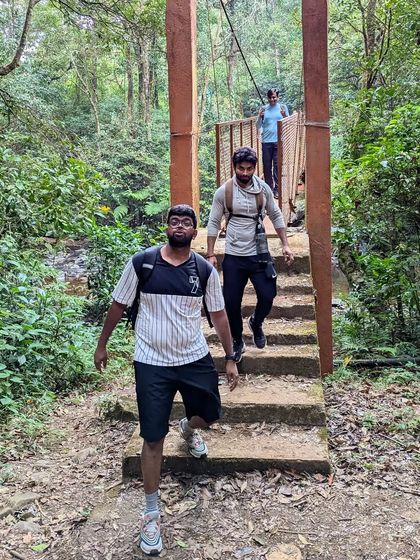 A happy trekker crossing the bridge, full of energy for the climb ahead.