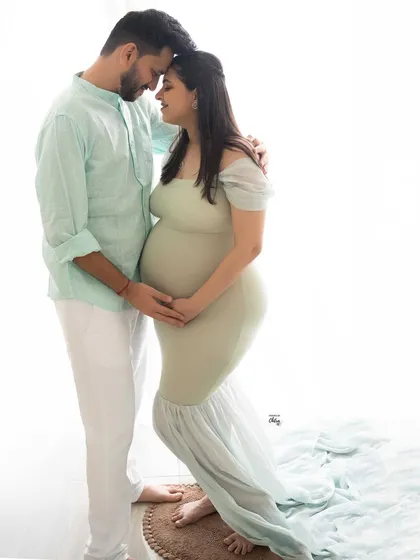 Soft light, sweet smiles, and the beginning of a new journey together. This light and airy couple's portrait, styled in gentle pastels, captures the serene happiness of expecting.