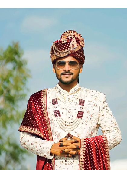 A picture-perfect groom. This client is wearing a classic cream-colored embroidered sherwani with a matching safa (turban) and mala (necklace) for his wedding day.