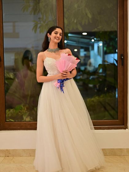 The model posing with a bouquet of roses.