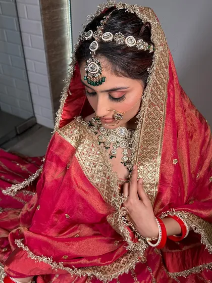 A series of a bride in a traditional red and gold silk lehenga. The poses and styling are perfect for creating a classic, timeless bridal album.
