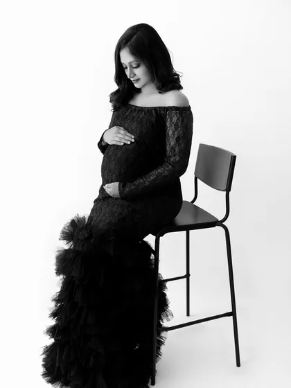 A timeless black and white portrait of a mom-to-be in our black lace off-the-shoulder gown.