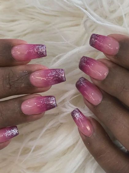 A glamorous take on ombré with a pink gradient base and sparkling purple glitter tips on square nails.