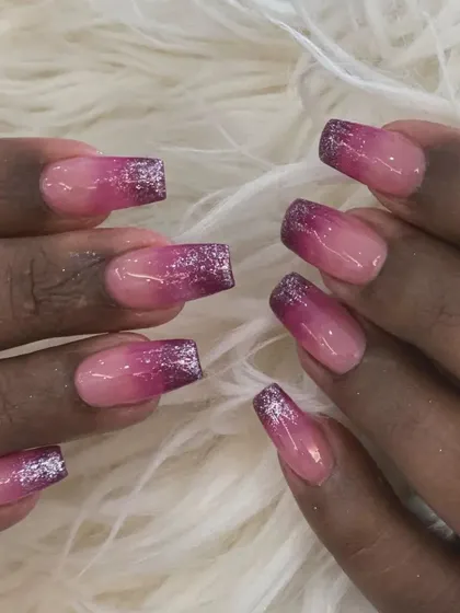 A glamorous take on ombré with a pink gradient base and sparkling purple glitter tips on square nails.