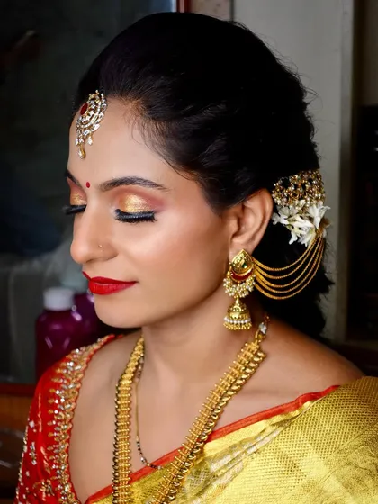 A serene portrait of the bride with her eyes closed, showcasing the beautiful sunset-hued eyeshadow and flawless base makeup.