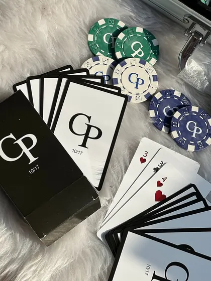 A close-up of the custom playing cards from the personalized poker set, featuring the couple's initials and their special date. It's these little details that make a gift memorable.