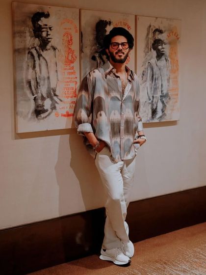 The full outfit against an artistic backdrop. This look is all about combining personal design with comfortable, stylish pieces for a long day of promotions.