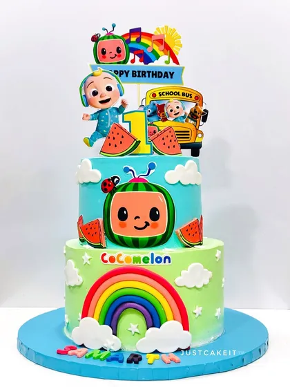 A vibrant three-tier Cocomelon cake, perfect for a big first birthday party. The bright colors and familiar characters are sure to be a hit with the little ones.