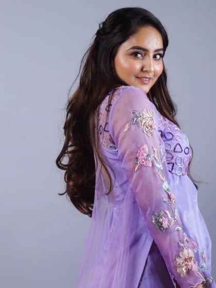 A closer look at our purple lehenga with a sheer embroidered overlay. The geometric and floral appliqué work on the bodice and sleeves adds a layer of modern artistry to the traditional silhouette.