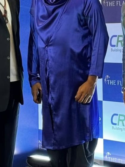 Another group photo with The Sivamani Trio, standing in front of the event branding.