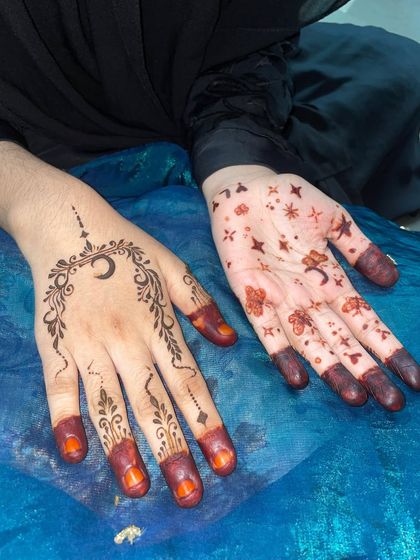 A Ghibli-inspired art style henna, with a crescent moon on one hand and scattered stars and flowers on the other.