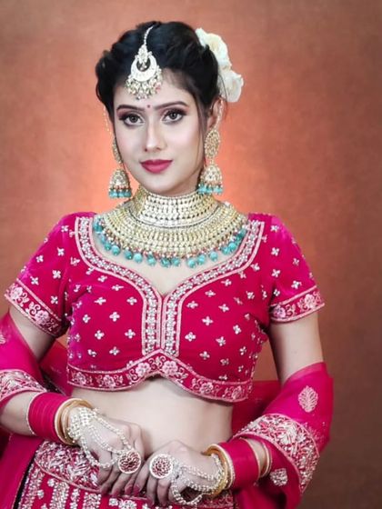 A bride in a pink velvet lehenga wearing a turquoise-beaded choker set. This demonstrates my ability to provide jewellery that matches even unconventional lehenga colors.