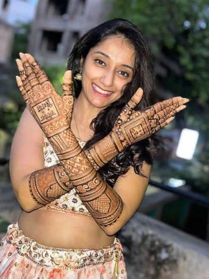 A radiant smile from a client delighted with her intricate and personalized mehndi design.