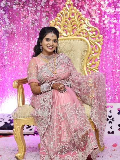 Here is one of our beautiful clients looking radiant on her reception day. She is wearing a modern American Diamond (AD) necklace set that sparkles beautifully under the lights. This set includes a layered choker and matching earrings, providing a glamorous look for contemporary events.