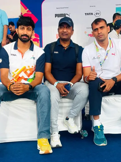 Sitting with fellow coaches and officials at a major athletics event. We work together behind the scenes to ensure everything runs smoothly for the athletes.