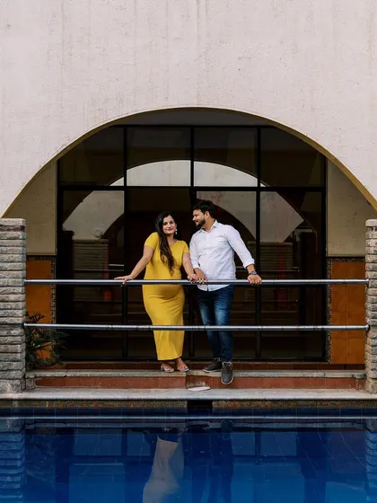 This poolside location with its strong architectural arch creates a dramatic frame for the couple. Her bright yellow dress adds a wonderful splash of color against the blue water.
