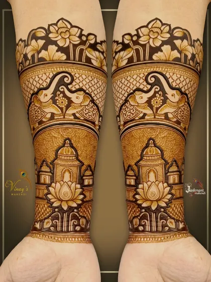 A close-up of the symmetrical forearm design with elephants, domes, and lotus flowers. The detail work is clean and precise.