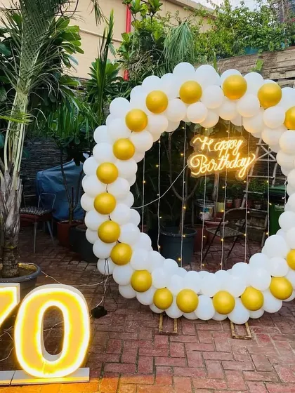 A close-up of the white and gold balloon ring for the 70th birthday, highlighting the simple yet classic color combination.