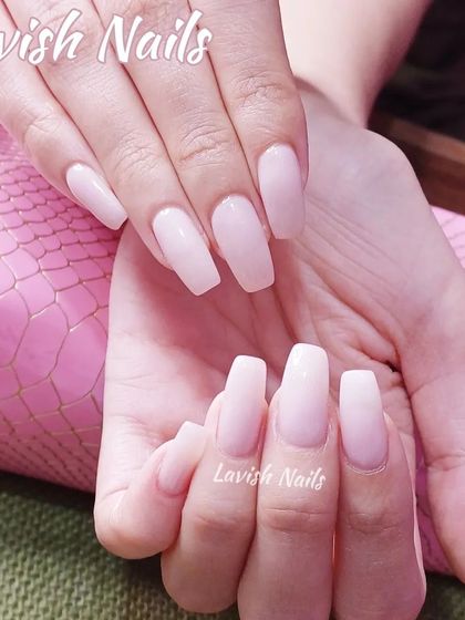 A simple and elegant set of long, coffin-shaped nails in a sheer, milky pink.