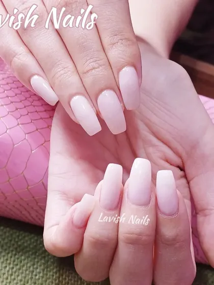 A simple and elegant set of long, coffin-shaped nails in a sheer, milky pink.