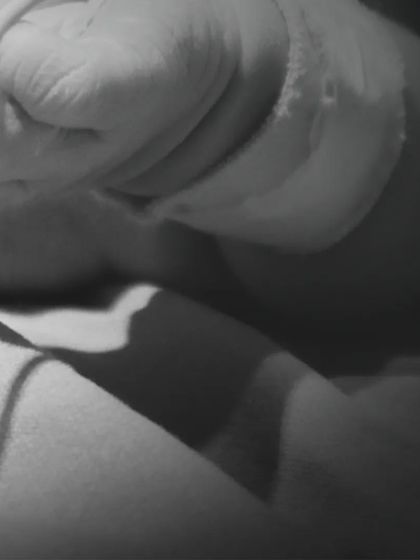 The tiny, clenched fist of a newborn, captured moments after birth. This image shows the strength and fragility of new life in a single frame.