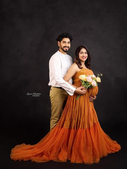 A happy and bright couple's portrait. The mustard gown and the beautiful bouquet of flowers add a cheerful and romantic touch to the scene.