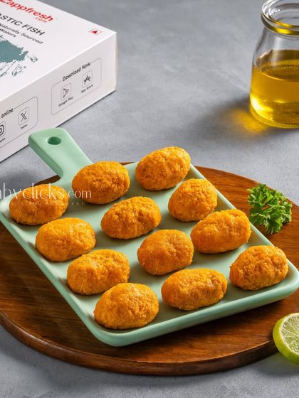 Fish nuggets from Zappfresh, arranged on a platter with the product box and a lemon wedge.