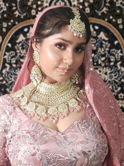 A close-up of the model in the pink lehenga, highlighting the flawless makeup and matching jewellery.