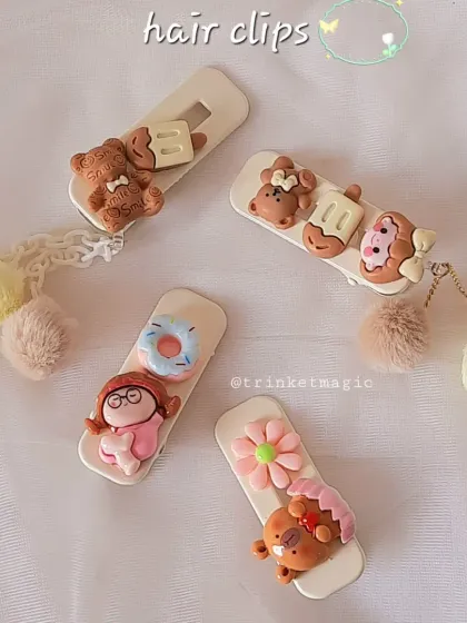 A flat lay of some of my favorite hair clip designs. You can see the little details, from the teddy bear charms to the dangling pom-poms, that make each piece special.